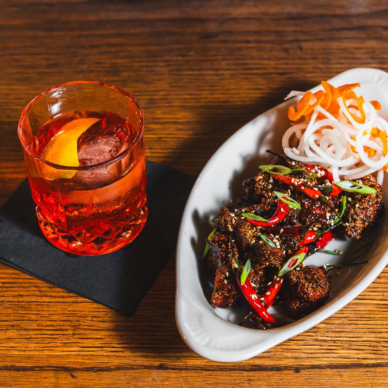 Korean-style fried chicken wings and a cocktail at Louie's Bar